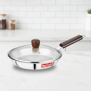 Max Fresh stainless steel frying pan with glass lid and dark wooden handle on kitchen countertop